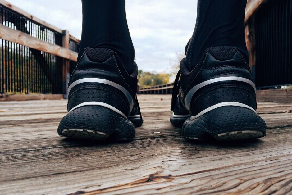 Close-up of athletic sneakers on a wooden bridge, capturing a runner's morning exercise routine.