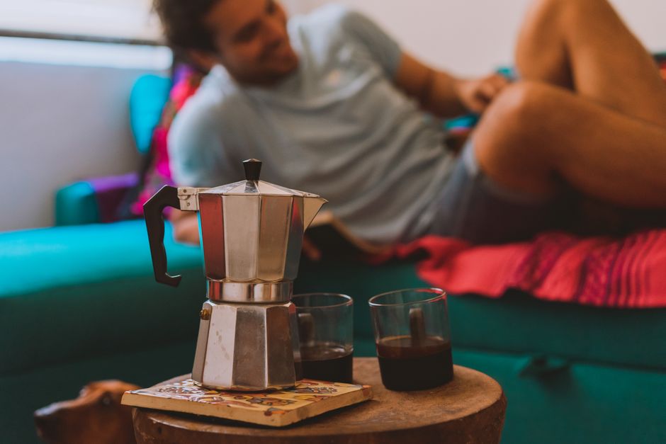 Warm indoor setting with a moka pot and coffee, capturing a moment of relaxation.