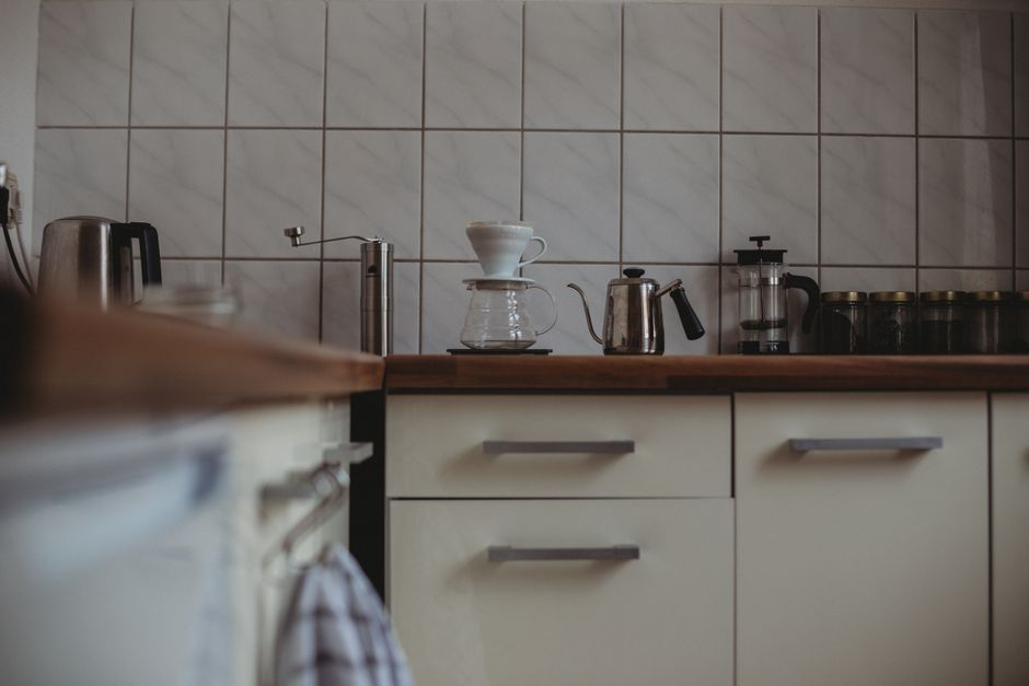 A cozy modern kitchen interior featuring various coffee-making equipment on the counter.