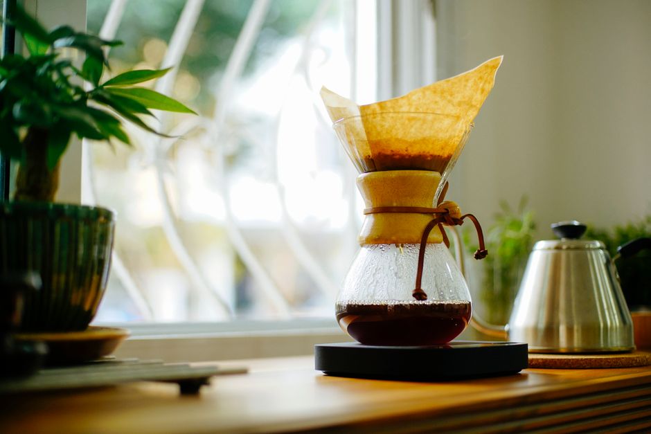 Elegant home coffee setup with Chemex brewer and kettle by the window. Perfect morning ambiance.