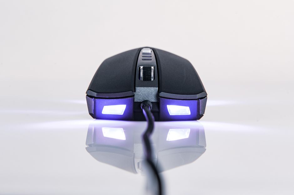Close-up of a wired gaming mouse with LED lights on a reflective surface.