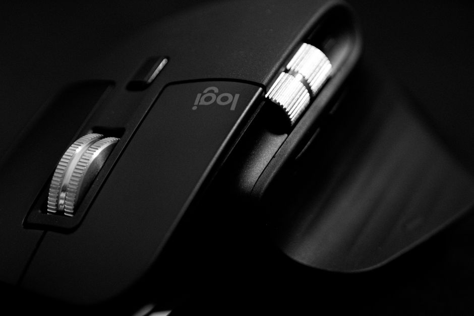 Close-up of a sleek, modern black gaming mouse with metallic scroll wheels.