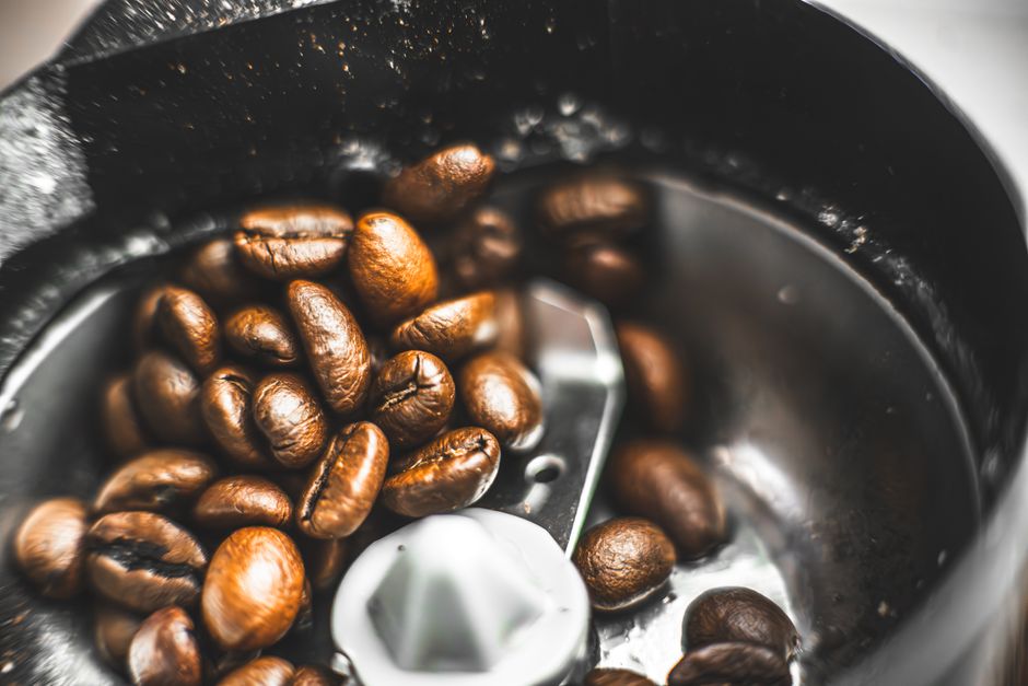 Fresh coffee beans in a grinder, ready for brewing a delicious cup of coffee.