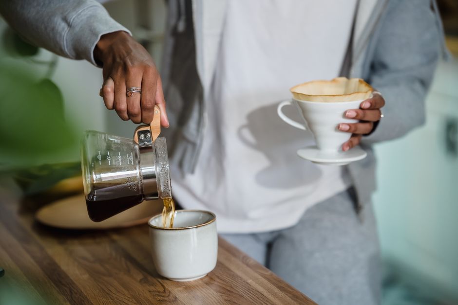 A close-up of a woman making coffee at home, capturing a cozy moment.