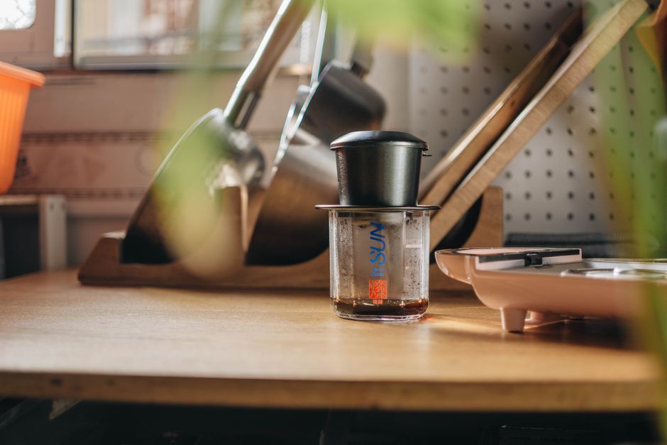 A cozy kitchen featuring a coffee maker and kitchen tools on a wooden counter, emphasizing a warm home vibe.