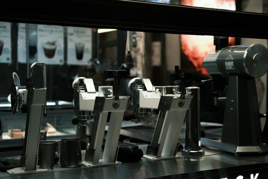 A close-up of modern coffee machines in a bustling café setting, highlighting sleek design.