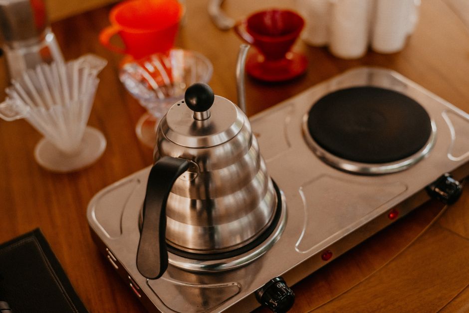A stylish coffee brewing setup featuring a stainless steel kettle and drip filters on a wooden surface.