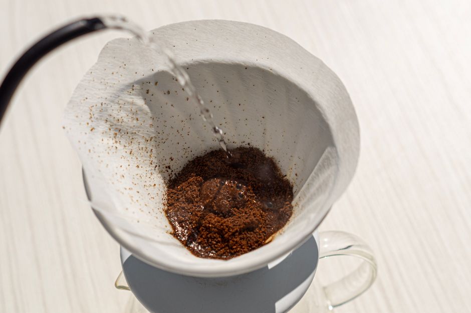 Close-up of steaming coffee grounds in a filter during a pour-over brewing process.