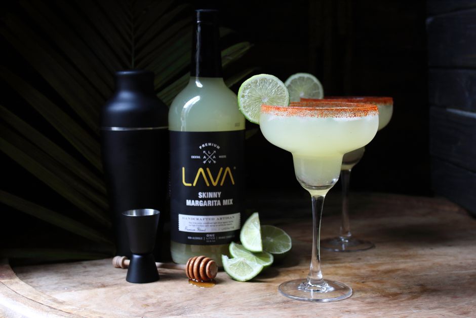 Lime margaritas with salt rim on wood featuring Lava mixer bottle. Perfect for cocktail enthusiasts.