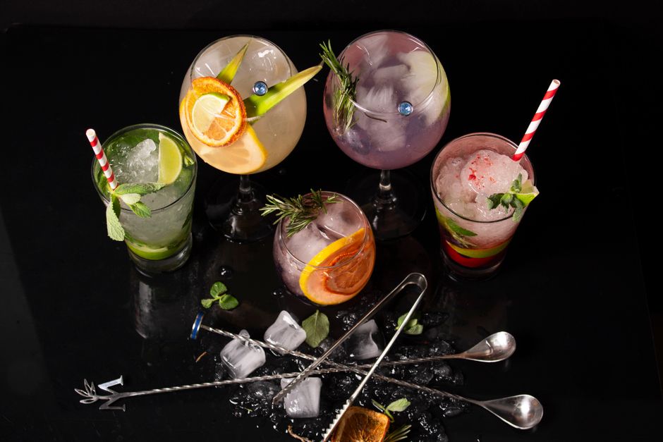 A vibrant assortment of cocktails garnished with citrus slices and mint leaves, perfect for a summer gathering.